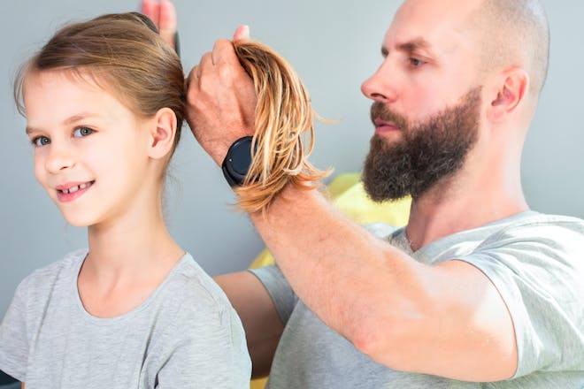 Man ties daughter's hair 