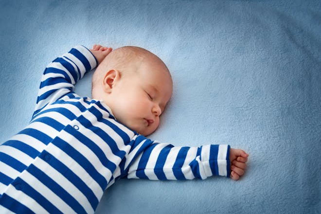 Sleeping baby in striped babygro