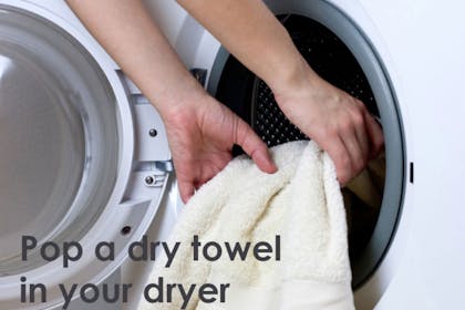 hands putting blanket in dryer