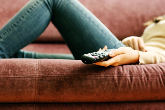 woman on sofa holding remote control