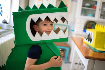 A boy dressed up in costume as Rex the dinosaur for Toy Story party