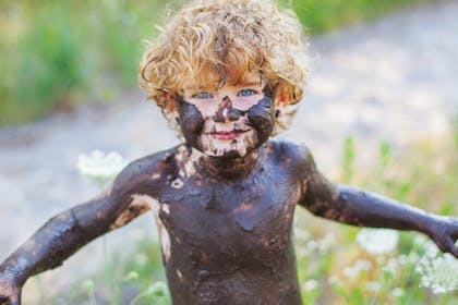 Little boy covered in mud
