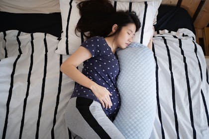Pregnant woman sleeping with pregnancy pillow
