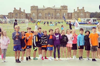 Children line up for a photograph in front of Holkham Hall at the Festival of Sport