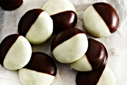 Peppermint creams half dipped in chocolate on a plate