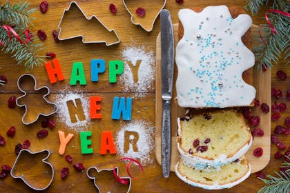 A sliced up cake with Happy New Year spelled out next to it
