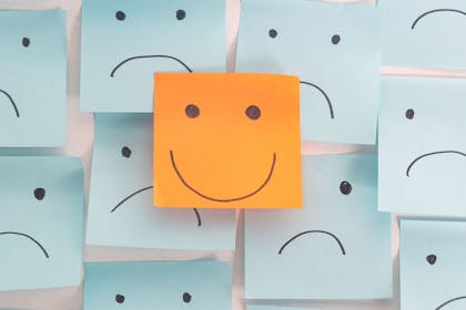 Post it notes with smiling and unhappy faces drawn on