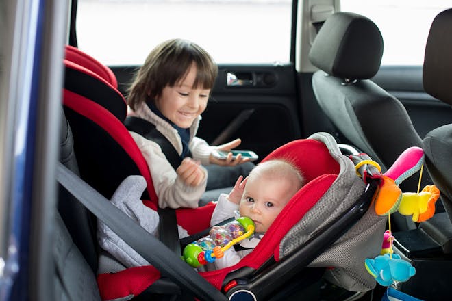 young child in forward-facing car seat and baby in backward-facing car seat