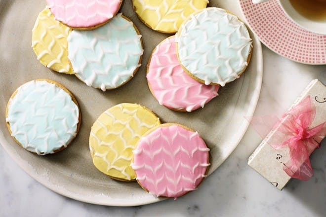 Plate of biscuits iced in pastel colours