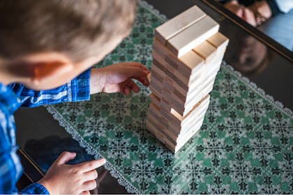 A kid plays a game of jenga