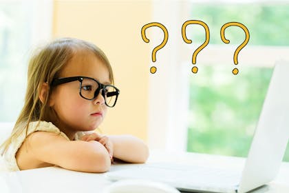 Toddler wearing glasses and looking at laptop with question marks in air