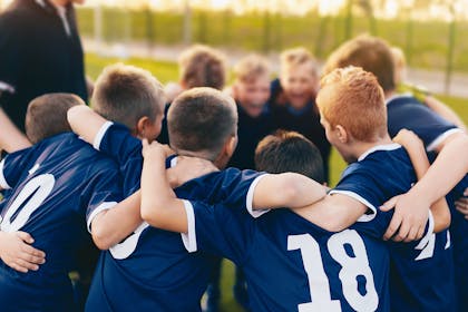 group of boys playing football in a huddle