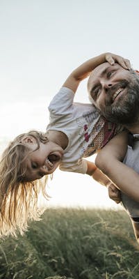 Man carrying daughter on shoulders