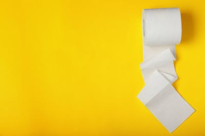 roll of toilet paper on yellow background