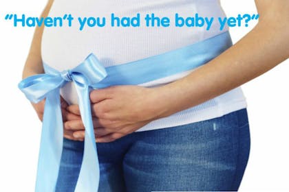 woman's pregnant belly with blue ribbon wrapped around it