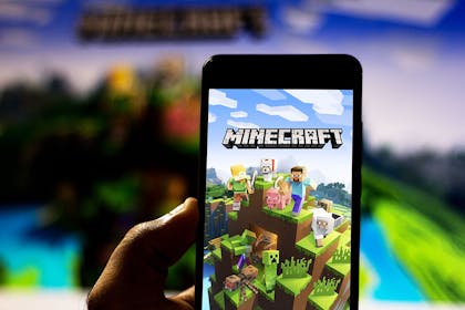 Child holding phone with the Minecraft app downloaded