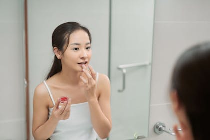 girl putting on lip balm from party bag