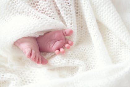 Baby's feet poking out from under a blanket