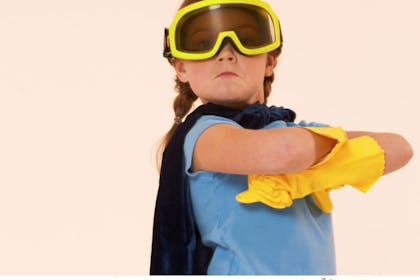 girl in blue shirt wearing gloves, goggles and cape