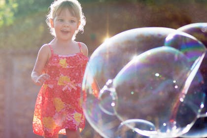 girl running towards giant bubble