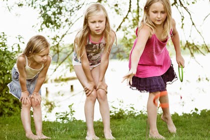 Three young girls throwing rings in game of ring toss