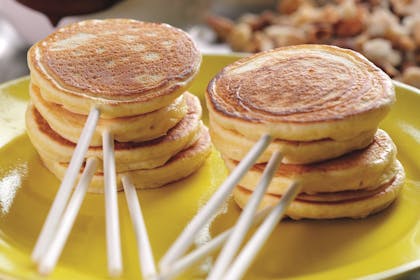 Lollypop pancakes. An easy pancake recipe for kids, featuring mini orange pancakes on sticks with chocolate dipping sauce. Try this recipe for Pancake Day