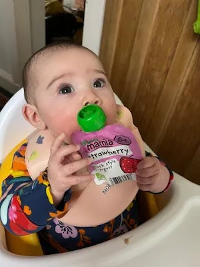 Baby holding Mamia Greek Style Yogurt pouch