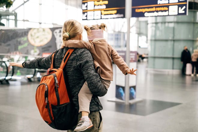 single parent at airport with child going on holiday