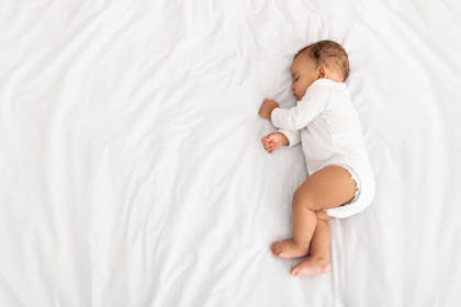 baby asleep on white sheet