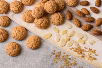 Amaretti biscuits sat on kitchen top with chopped almonds