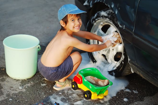Young boy washing car