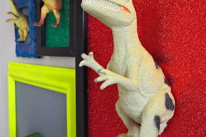 A display of toy dinosaurs glued into picture frames