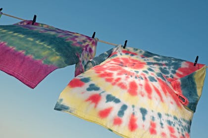 two tie dye t-shirts on a washing line