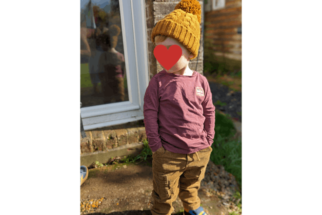 Toddler wearing yellow bobble hat