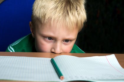 Child with ADHD looking at homework