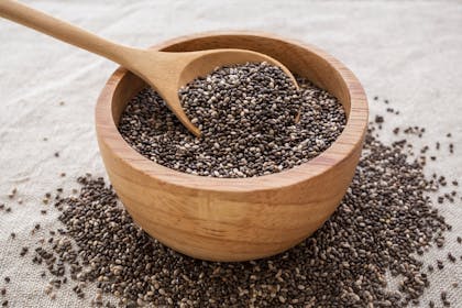 Wooden spoon and bowl of dry chia seeds