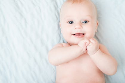 Baby lying on back and smiling