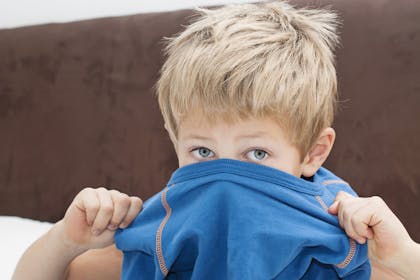 Boy getting himself dressed for school