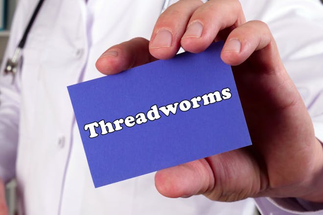 Man holding sign saying threadworms
