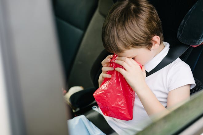 Child being sick into a bag