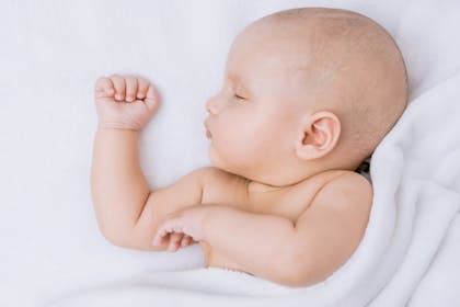 Young baby sleeping in white blanket