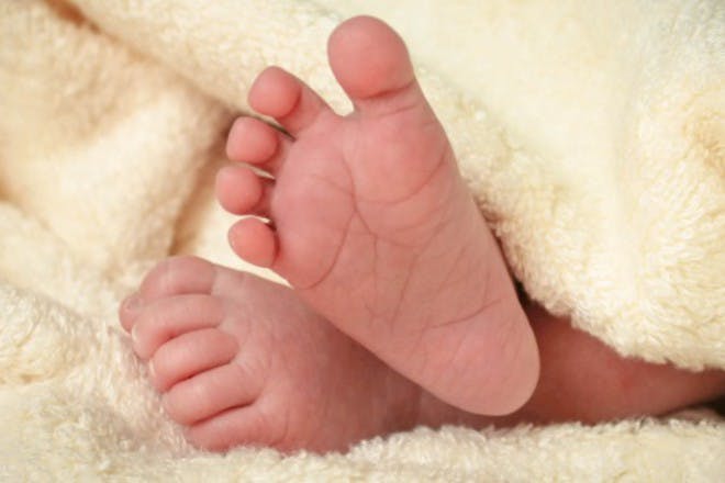 newborn baby feet under blanket