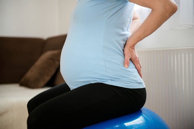 A pregnant woman experiencing back pain in pregnancy