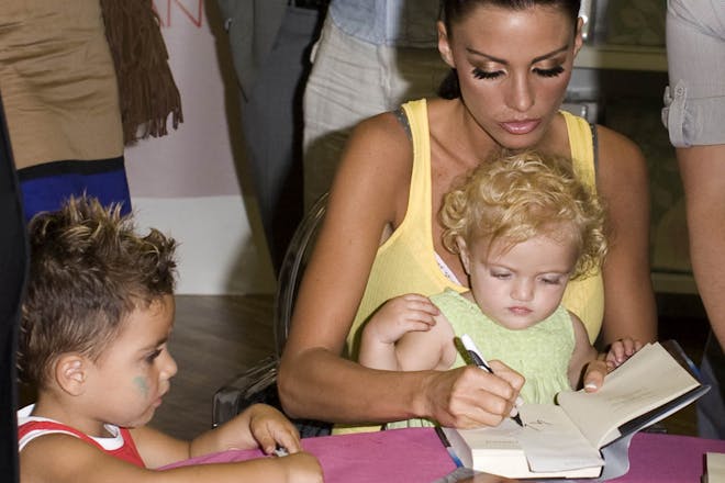Katie Price signs books with baby daughter on lap