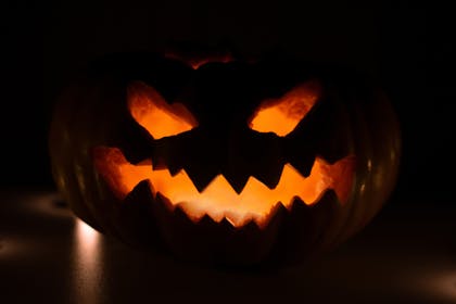 Close up of a scary carved pumpkin in a dark room