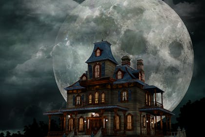 A creepy haunted house with a huge moon behind