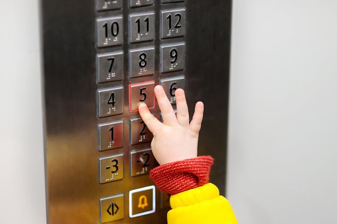 child pressing lift buttons