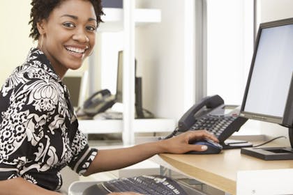 woman smiling while working reception - School receptionist