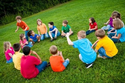kids playing duck duck goose outdoors