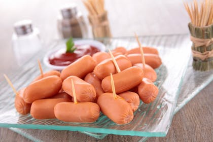 A plate of cocktail sausages on sticks